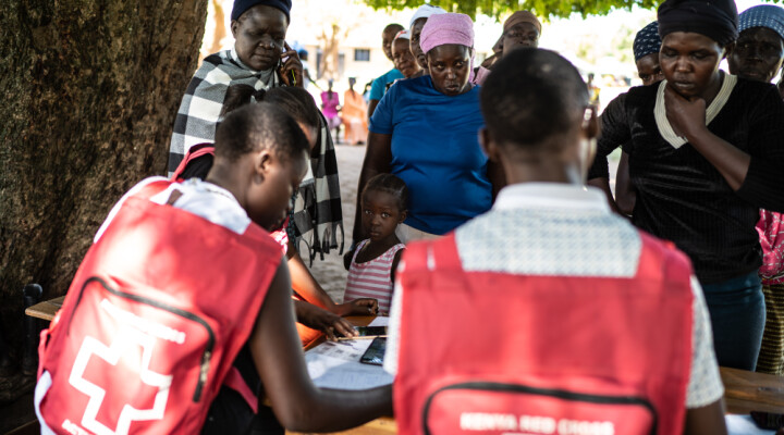 Women and children displaced by flooding register with Kenyan Red Cross for a pop-up medical clinic in Osodo, Homa Bay, Kenya, Tuesday, Dec 17, 2019. Heavy rains have hit Kenya particularly hard this year, killing crops and displacing tens of thousands of people throughout the country. Mackenzie Knowles-Coursin/ICRC