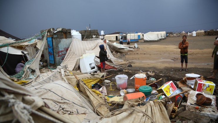 Displaced children look at what's left of their tent after the floods swept through their camp on the outskirts of Marib. © Saleh Alaroosi/ICRC