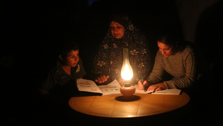 A mother of six is helping two of her children to study during a blackout