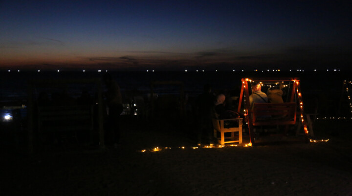 A group of people is sitting at the beach during the night in Gaza